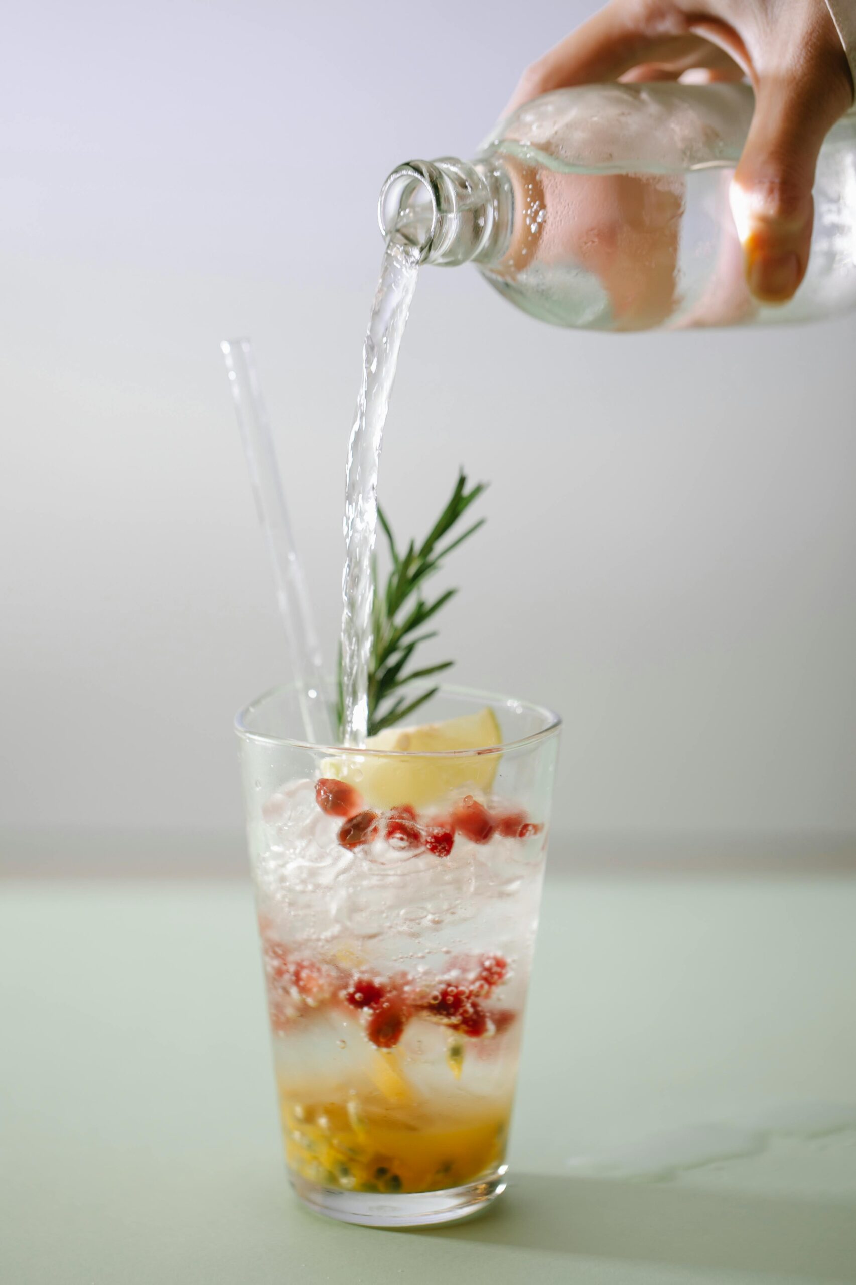 Enjoy a citrus and pomegranate cocktail with rosemary garnish, perfect for a refreshing drink.